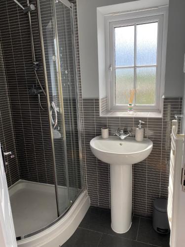 a bathroom with a sink and a shower at Stunning, contemporary Home from Home in Heckmondwike