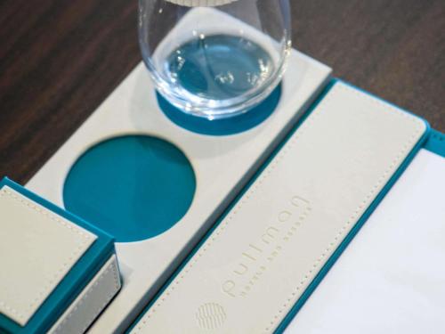 a glass of water sitting on top of a table at Pullman Taiyuan in Taiyuan