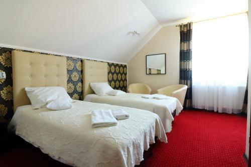 dwa łóżka w pokoju hotelowym z ręcznikami na nich w obiekcie Pokoje Gościnne Anna Airport Modlin w Nowym Dworze Mazowieckim