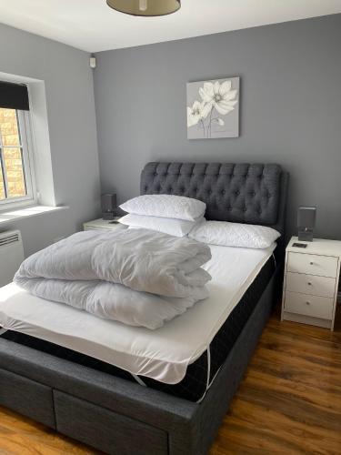 a bedroom with a large bed with a leather headboard at Stunning, contemporary Home from Home in Heckmondwike