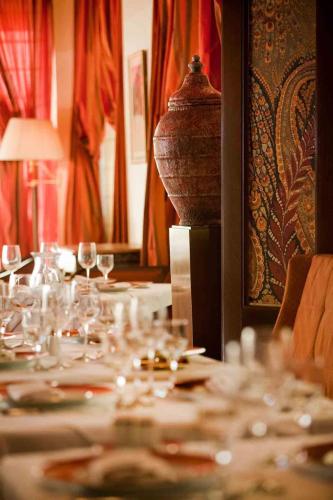a table with wine glasses and a vase on it at Royal Hotel Oran - MGallery Collection in Oran