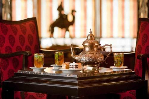 a table with a tea kettle and glasses on it at Royal Hotel Oran - MGallery Collection in Oran