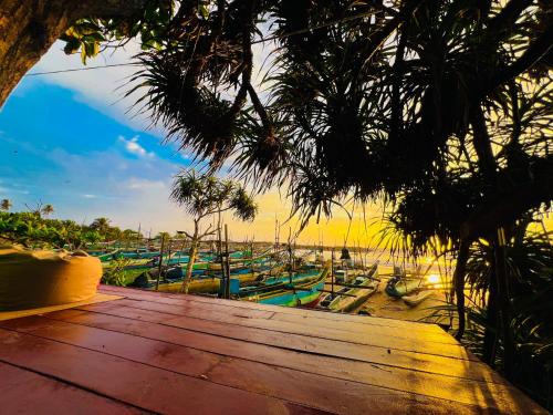 a wooden deck with many boats on the beach at Ayaan Beach Home in Dodanduwa