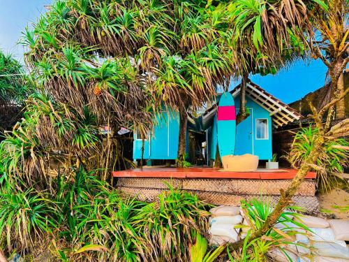 a small house with a blue and pink lighthouse at Ayaan Beach Home in Dodanduwa