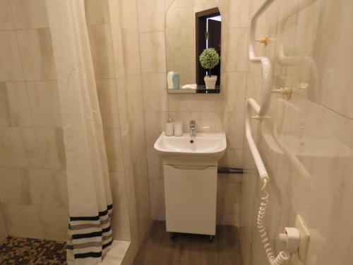 a white bathroom with a sink and a shower at Just comfort in Odesa