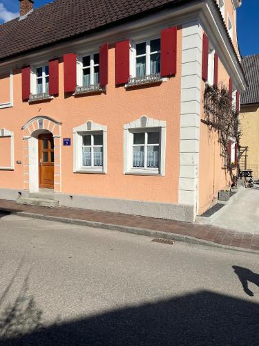 a building with red and white windows on a street at Anna9 - Penthouse Suite nahe Legoland Günzburg in Ichenhausen