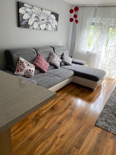 a living room with a gray couch and wooden floors at Stunning, contemporary Home from Home in Heckmondwike