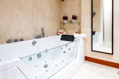 a bath tub in a bathroom with a mirror at AMAZING ROOFTOP, 70 M TERRACE,Pool,BEACH,PARKING in Málaga