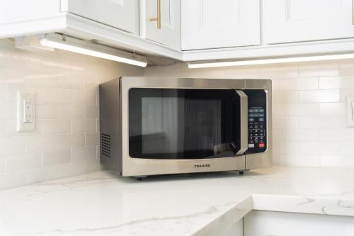 a microwave oven on a counter in a kitchen at Charming 3-Bed House with Hot Tub close to Downtown in Barrie
