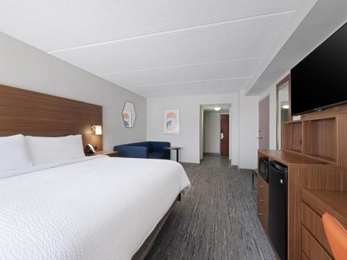 a hotel room with a bed and a flat screen tv at Holiday Inn Express & Suites Augusta West - Ft Gordon Area by IHG in Augusta
