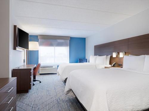 a hotel room with two beds and a desk at Holiday Inn Express & Suites Augusta West - Ft Gordon Area by IHG in Augusta