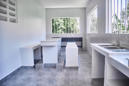 een witte keuken met een wastafel en een tafel bij Smile Apartments Arusha in Arusha