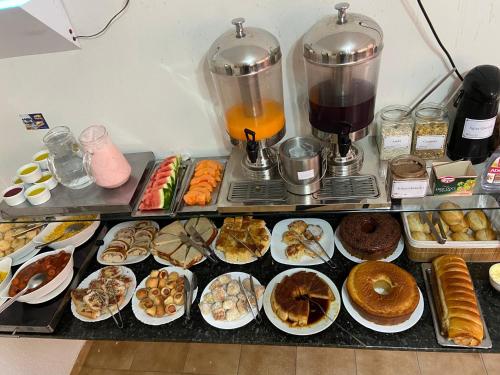 een toonbank vol met allerlei soorten gebak bij Une Hotel in Uberlândia
