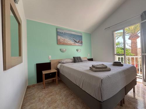 a bedroom with a bed and a large window at Blu Green Oasis 1214 By Lucapropertiesgrancanaria in Maspalomas