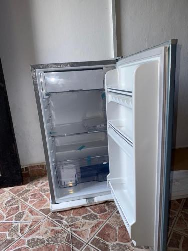 un réfrigérateur vide avec une porte ouverte dans une pièce dans l'établissement Raine house, à Ukunda