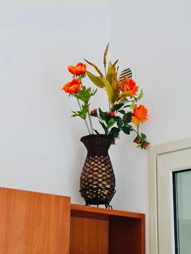 a vase with flowers sitting on top of a cabinet at Il Carrubo&Castagno Casette vacanza in Villaggio Azzurro