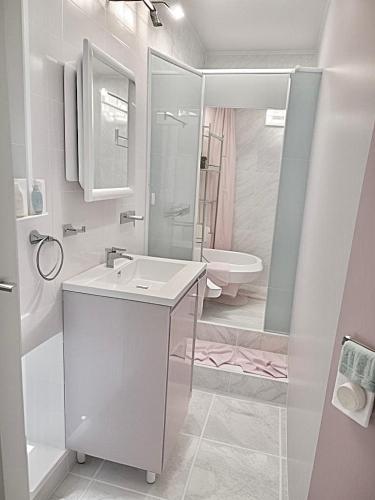 a white bathroom with a sink and a shower at Ethlyn House in Bocas del Toro