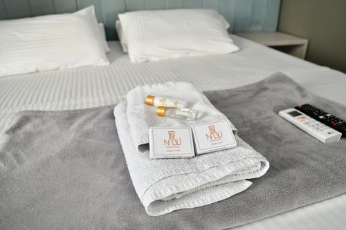 a pile of towels on a bed with a remote control at HOTEL NABU DEL PACIFICO in Tumaco