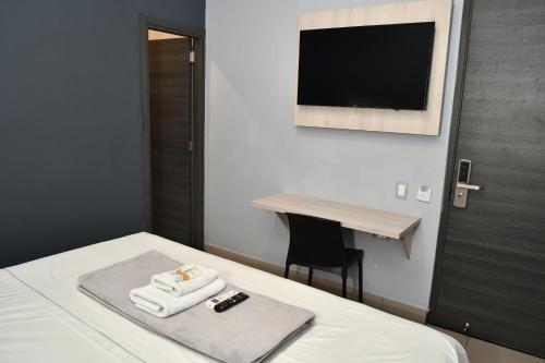 a hotel room with a bed with towels and a desk at HOTEL NABU DEL PACIFICO in Tumaco
