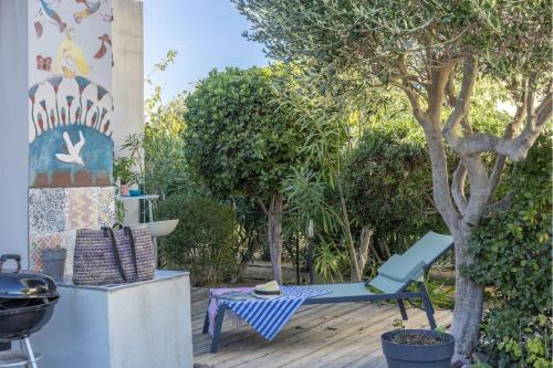 une chaise bleue assise sur une terrasse à côté d'un arbre dans l'établissement Casa Azul Turquesa, à Lumio