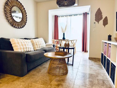 een woonkamer met een bank en een tafel bij LAGON BLEU - Proche Gare Routière - Terrasse & Piscine - 3Km PLAGE - PARKING & WIFI Gratuit - OFFRE SPECIALE in Fréjus