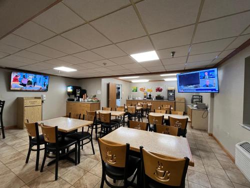 a dining room with tables and chairs and televisions at Quality Inn Arena in Wilkes-Barre