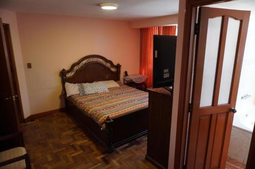 a small bedroom with a bed and a television at La Paz Home in La Paz