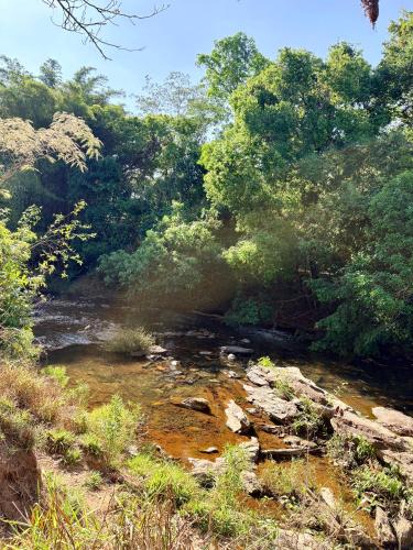 a stream of water with trees in the background at Loft Dreamtime - a 80 metros do Rio das Almas! in Pirenópolis