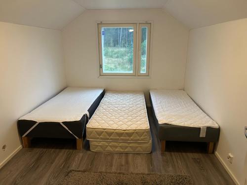 two beds in a small room with a window at Villainkoo in Rödbrått