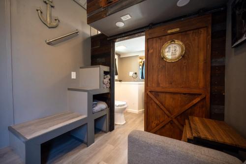 a bathroom with a wooden door and a toilet at Tiny House Pirate Ship - Sleeps 2 near Siesta Key beach in Siesta Key