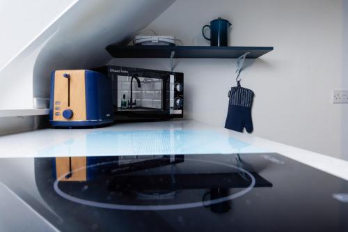 a kitchen with a counter with a toaster and a microwave at North Harbour View in Lerwick