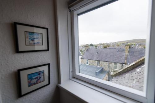 a window in a room with pictures on the wall at North Harbour View in Lerwick