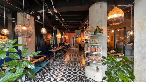 a restaurant with tables and potted plants in a room at Seissta Medellín in Medellín