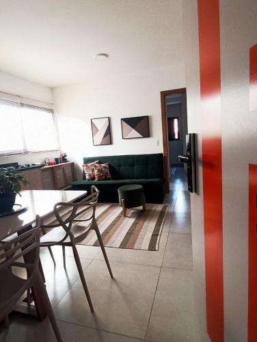a living room with a green couch and a table at Apê no Centro, Apé no Centro in Poços de Caldas