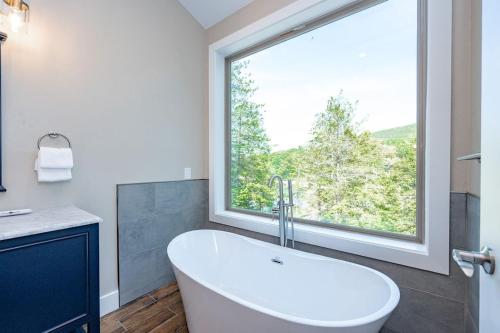 a white tub in a bathroom with a large window at Blue Anchor in Swanton