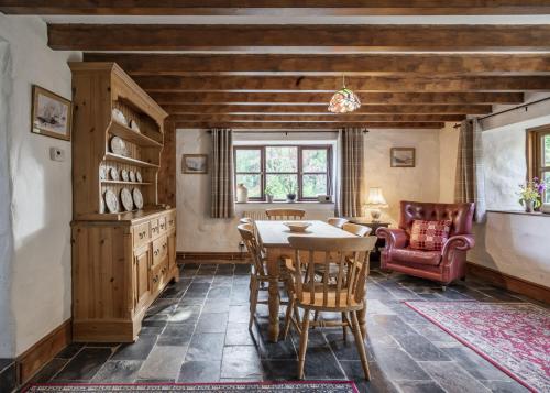 une salle à manger avec une table et des chaises dans l'établissement Cove Cottage, à Llandysul