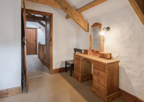 La salle de bains est pourvue d'une commode en bois et d'un miroir. dans l'établissement Cove Cottage, à Llandysul