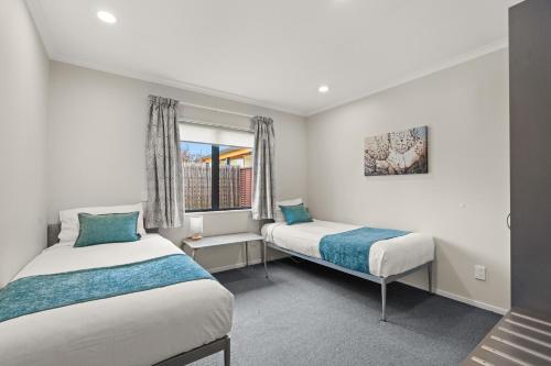 a room with two beds and a window at ASURE Oak Estate Motor Lodge in Greytown