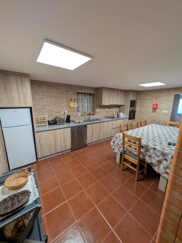 a large kitchen with a table and a counter at Casa do Terreiro in São João de Tarouca