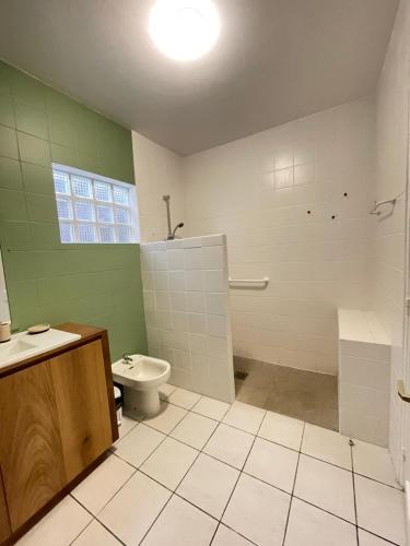 a green and white bathroom with a toilet and a sink at La Terrasse des Maldives in Saint-Paul