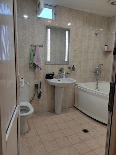 a bathroom with a sink and a tub and a toilet at Apartment in Tʼelavi