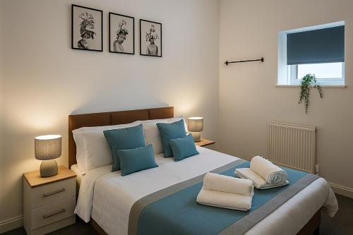 ハダーズフィールドにあるThe Signature Residenceのベッドルーム1室(大型ベッド1台、青と白の枕付)