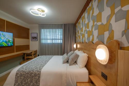 a hotel room with a bed and a flat screen tv at Hotel Boutique Casa Flor de Café in Mexico City