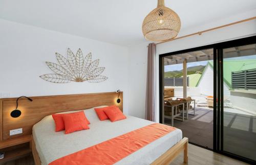 una camera da letto con un letto con cuscini arancioni sopra di Love Penthouse a Orient Bay