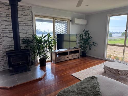 a living room with a television and a fireplace at Entire home near South West Rocks Beautiful Views in Pelican Island