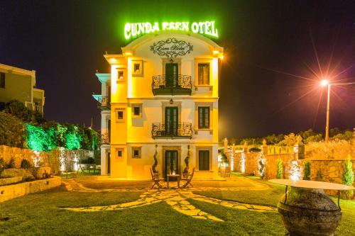 a building with a green sign on top of it at Cunda Esen Hotel in Ayvalık
