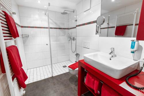 a white bathroom with a sink and a shower at Hotel-Restaurant Schwanen in Weil am Rhein