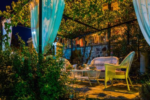 a patio with chairs and a table and an umbrella at Cunda Esen Hotel in Ayvalık
