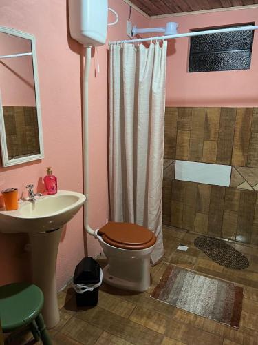 a bathroom with a toilet and a sink and a shower at Casa Cabana Harmonia in Santana do Livramento