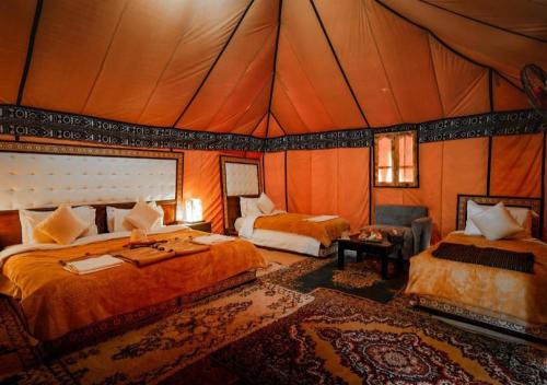 a bedroom with two beds in a tent at Treasure Desert Camp in Merzouga